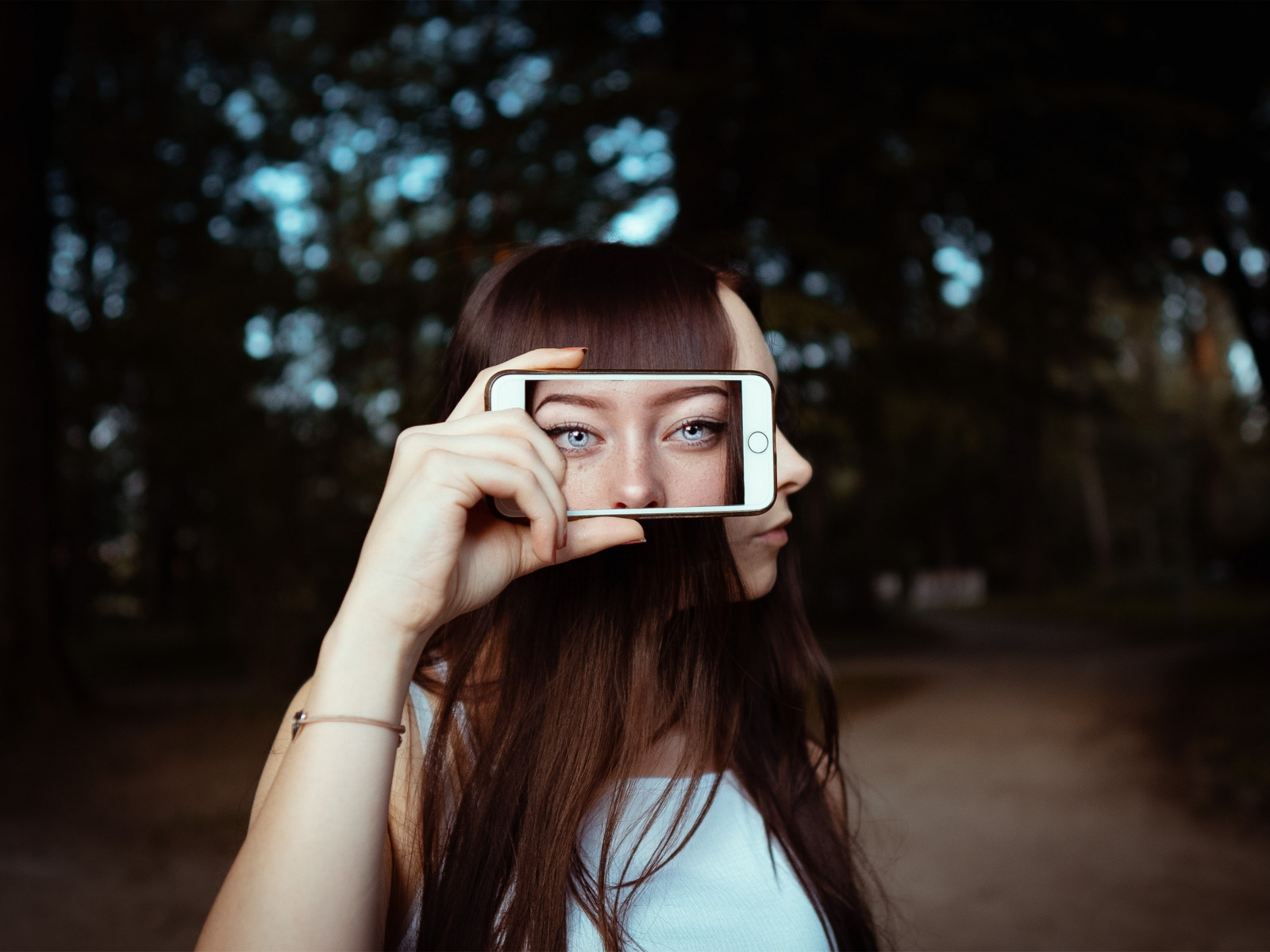 woman holding smartphone with background of woman s face 3887990