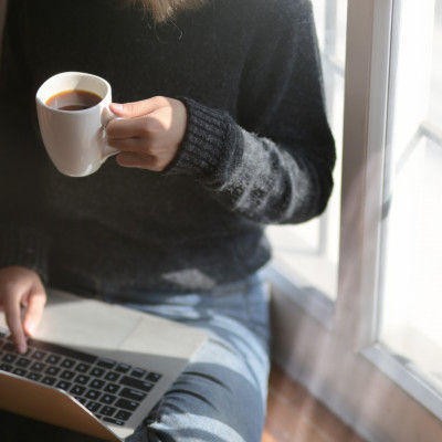 woman using laptop while holding a cup of coffee 3759083