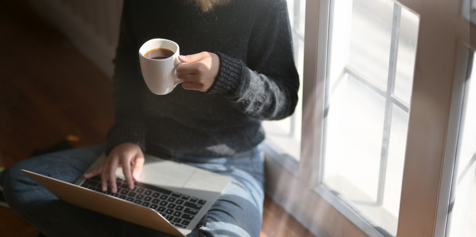woman using laptop while holding a cup of coffee 3759083